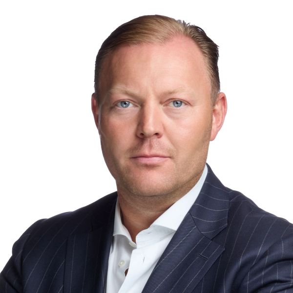 Professional Headshot of a Middle-aged Man in a Dark Pinstripe Suit and White Shirt Facing the Camera with a Neutral Expression Against a White Background